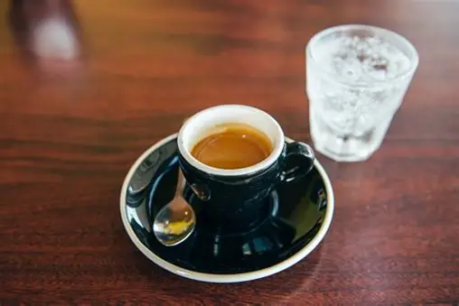 Empfangstisch mit Kaffeetassen und einem Glas Mineralwasser